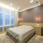 Stijlvolle suspension verlichting boven een bed in een moderne slaapkamer, die de ambiance verbetert.