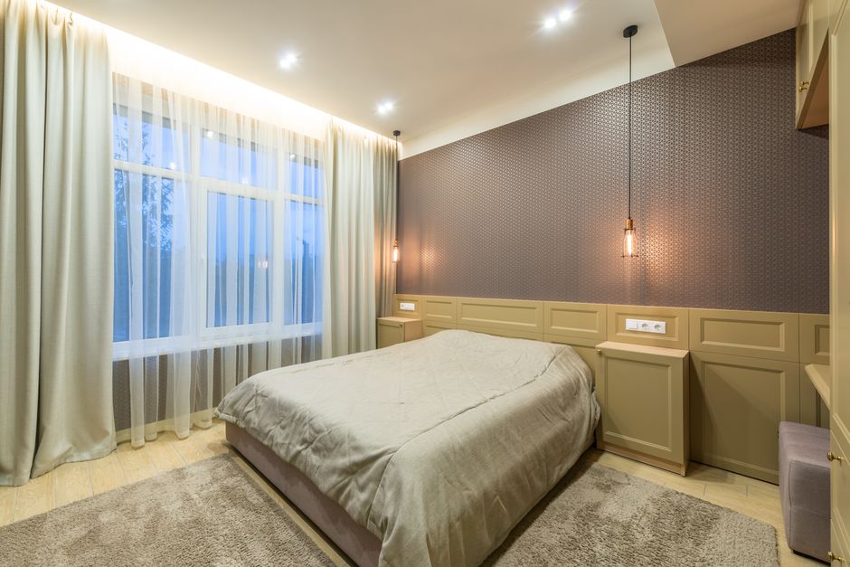 Stijlvolle suspension verlichting boven een bed in een moderne slaapkamer, die de ambiance verbetert.